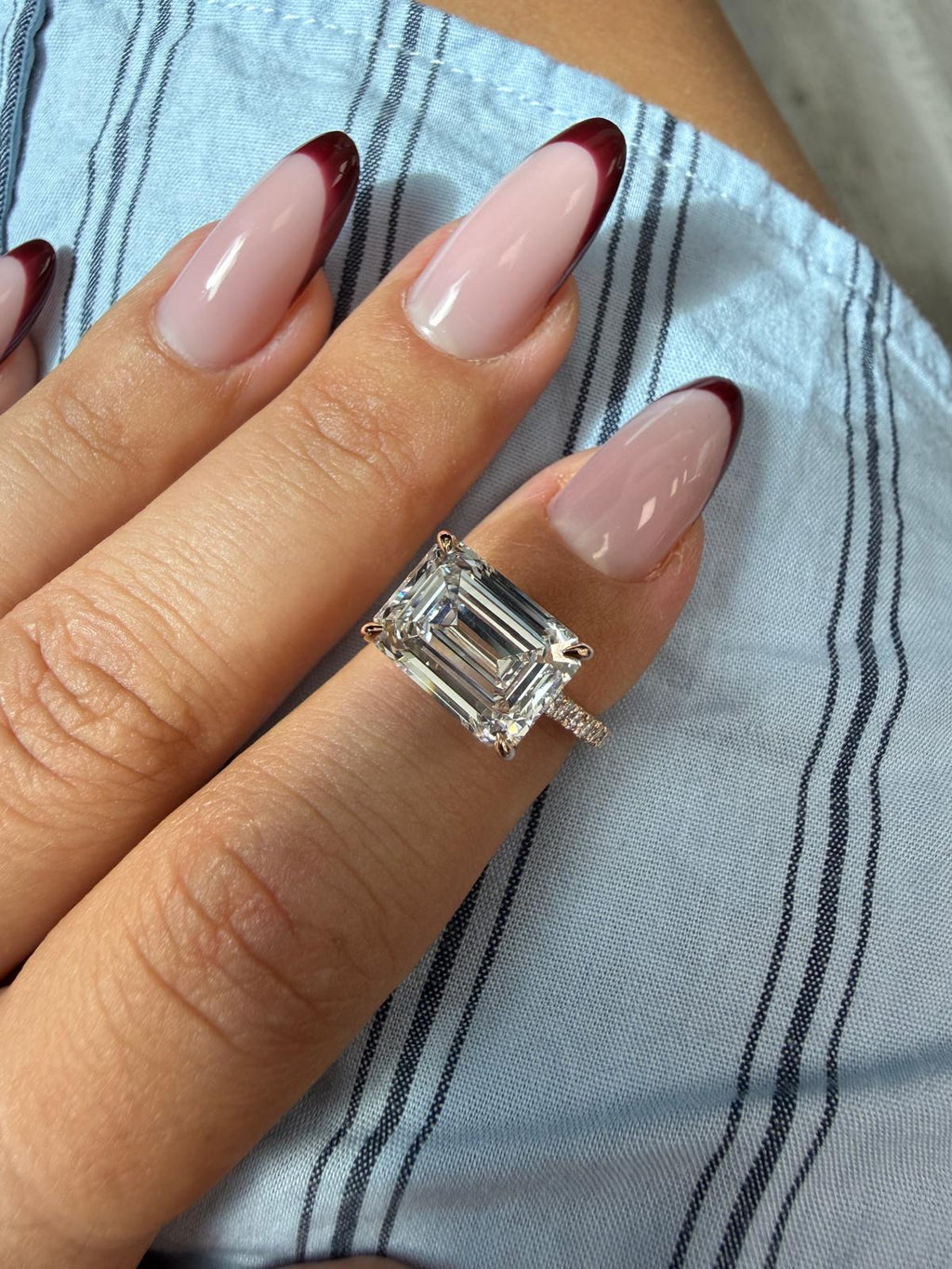 Costa east-to-west emerald cut engagement ring worn on the hand