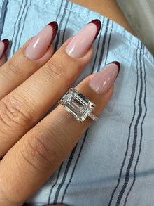 Costa east-to-west emerald cut engagement ring worn on the hand